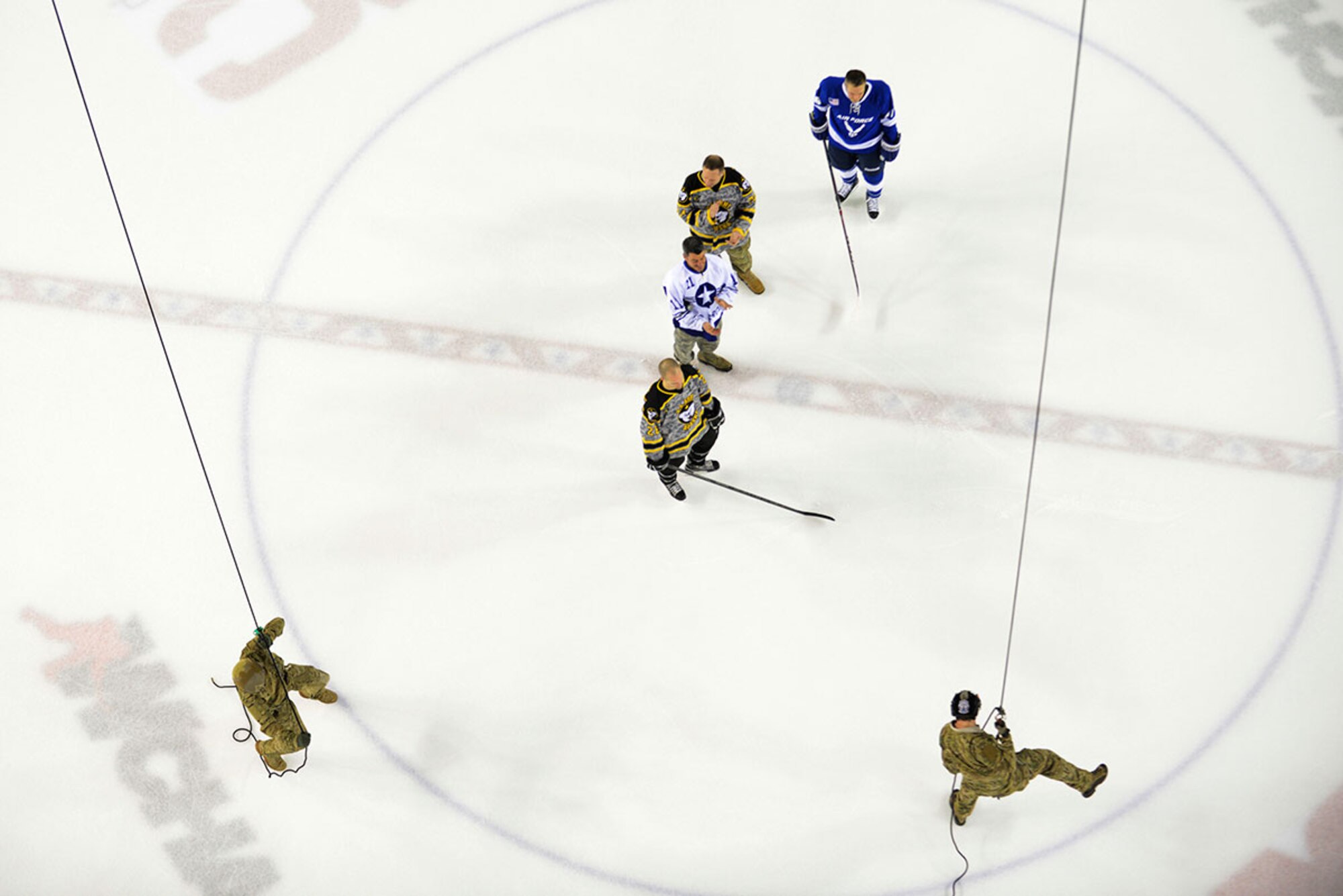 Master Sgt. Shane Hargis, left, and Staff Sgt. Sonny Carlos, right, rappel from the rafters during the Joint Base Elmendorf-Richardson Army vs. Air Force hockey game. The game promoted esprit de corps and was intended to enhance the relationship between JBER and the Anchorage community.  Hargis and Carlos are both pararescuemen with the 212th Rescue Squadron. (U.S. Air Force photo by Airman Valerie Monroy)