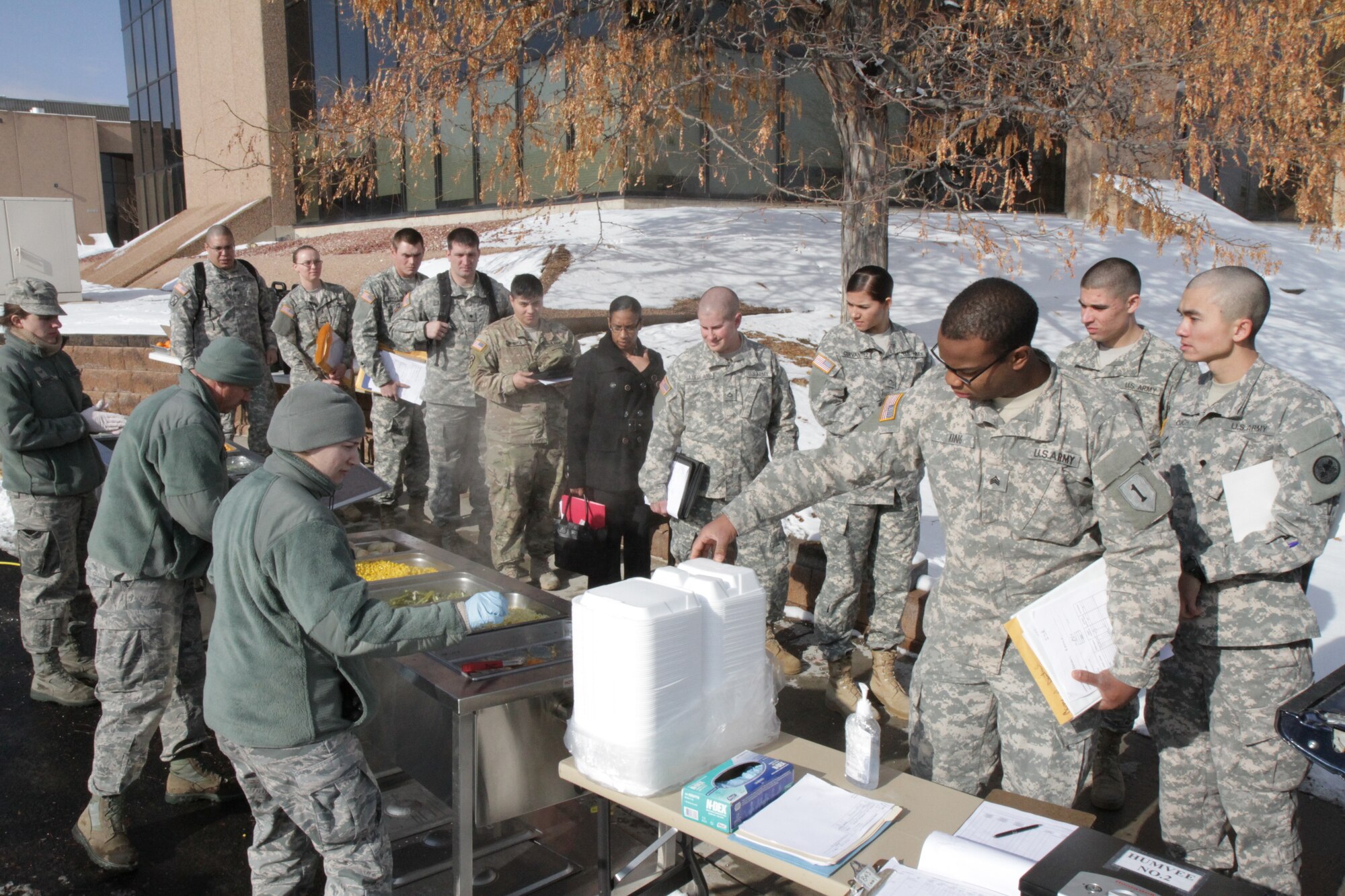 Colorado Guardsmen stand in line to receive lunch prepared in the Disaster Relief Mobile Kitchen Trailer at Joint Force Headquarters in Centennial, Colo., Jan. 9, 2016. The DRMKT was used in support of the simulated state active duty blizzard emergency response exercise. (U.S. Army National Guard Photo by Sgt. Ray Casares)