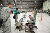 Senior Airman Nathan Durland, 25th Aircraft Maintenance Unit weapons load crew member, checks over munitions during the quarterly weapons loading competition on Osan Air Base, Republic of Korea, Jan. 8, 2016. As part of their monthly qualification standards each crew completed a written test before competing in a practical demonstration of loading capabilities. (U.S. Air Force photo/Staff Sgt. Amber Grimm/released)
