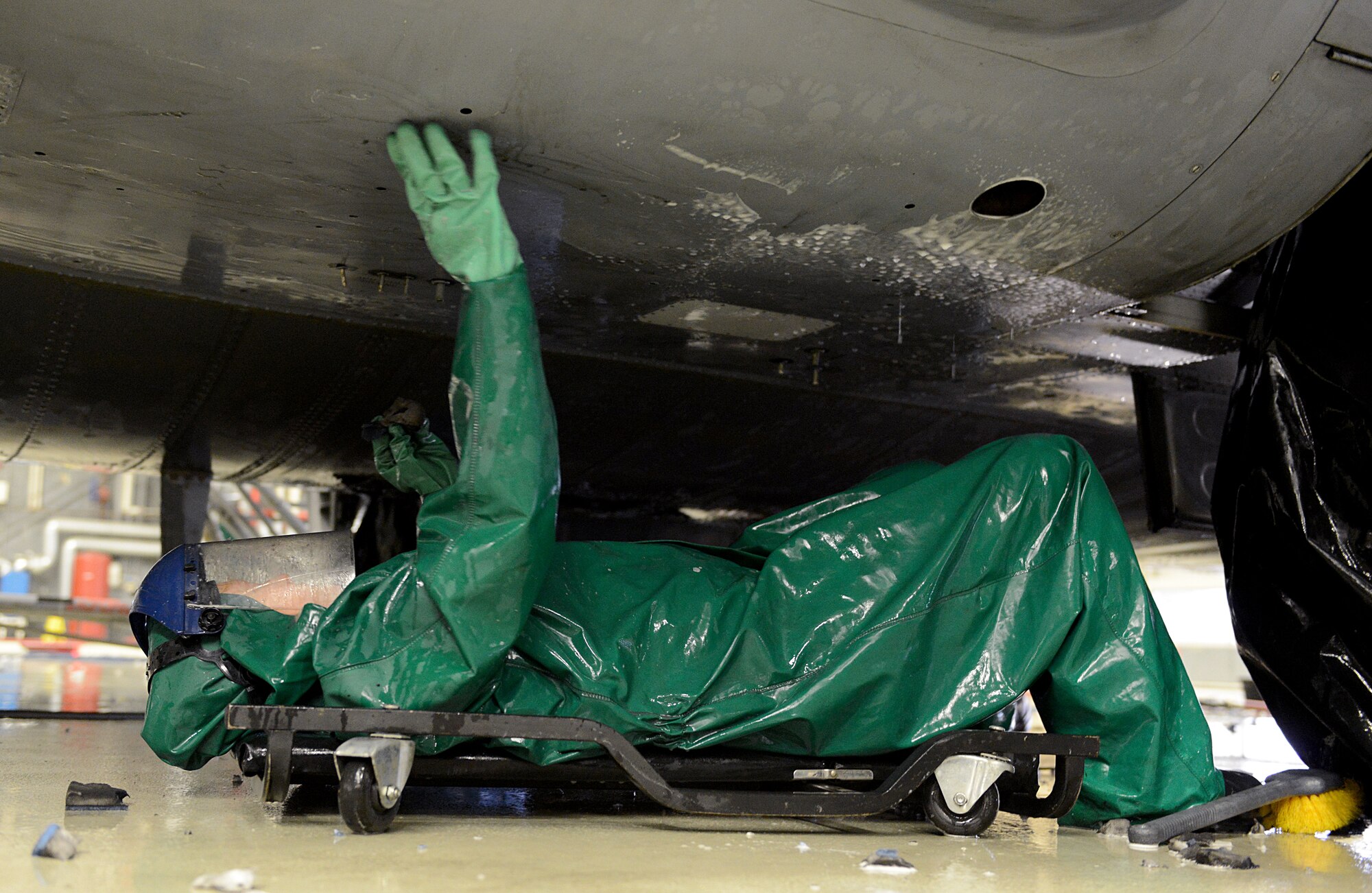 Capt. Rachel Weiler, 86th Maintenance Squadron maintenance flight commander, washes the underbelly of a C-130J Super Hercules Jan. 4, 2016, at Ramstein Air Base, Germany. The wash was performed before the aircraft’s C-2 isochronal inspection. (U.S. Air Force photo/Staff Sgt. Timothy Moore )