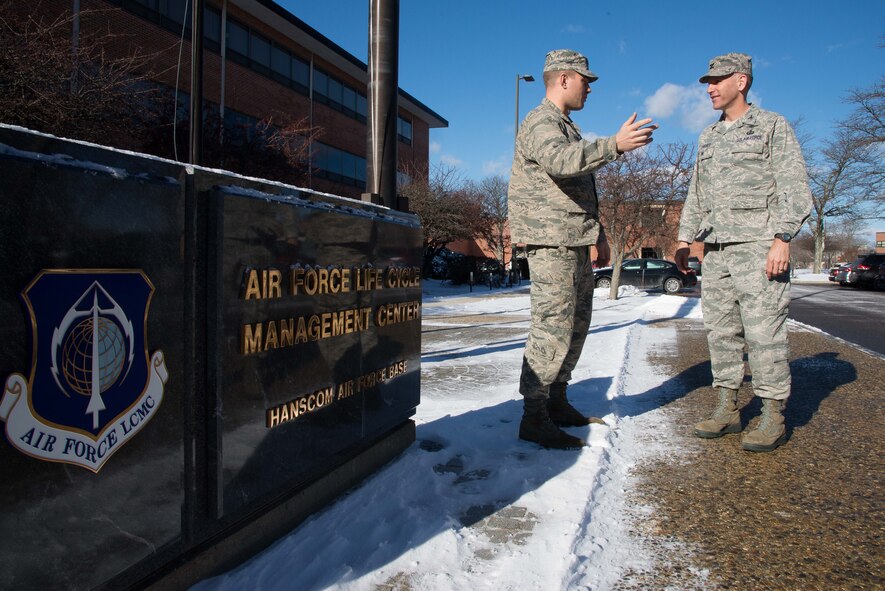 U.S. Air Force 1st Lt. George Steele, left, a program systems engineer, speaks with Col. David Learned, right, JSTARS Recapitalization senior materiel leader, about on-going communication system risk reduction efforts at Hanscom Air Force Base, Mass., Jan. 13, 2016. The communication system is one of four major components undergoing a recapitalization. The program officially reached a Milestone A decision in December and is currently in the Technology Maturation and Risk Reduction phase. (U.S. Air Force photo by Mark Herlihy)