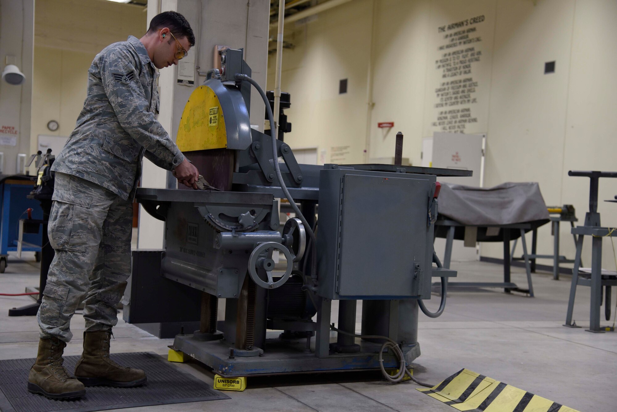 U.S. Air Force Senior Airman Charlton Long, an aircraft structural maintenance journeyman with the 35th Maintenance Squadron, trims a piece of metal with a disk sander at Misawa Air Base, Japan, Jan. 11, 2016. Disk sanders are used to shorten slices of metal used to construct replacement parts for aircraft. (U.S. Air Force photo by Airman 1st Class Jordyn Fetter)	