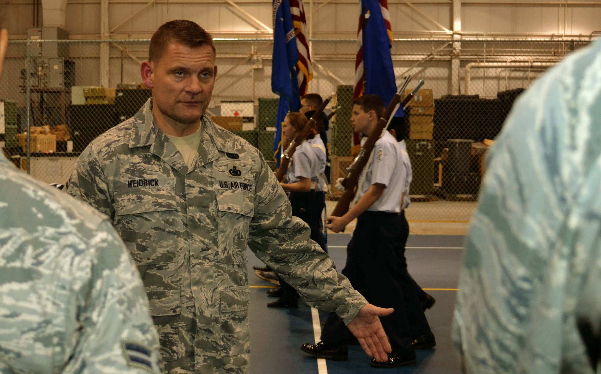 Senior Master Sgt. John Heidrick, the 111th Attack Wing vehicle maintenance manager and 111th ATKW Honor Guard NCO in charge, explains the movement of members from the Pottstown High School’s Air Force Junior Reserve Officer Training Course as they practice alongside the 111th ATKW Honor Guard Jan. 9, 2015 on the base basketball court at Horsham Air Guard Station, Pennsylvania. The Pottstown students attended the honor guard practice to gain insight on how the Air National Guard executes its movements. (U.S. Air National Guard photo/Tech. Sgt. Andria Allmond)