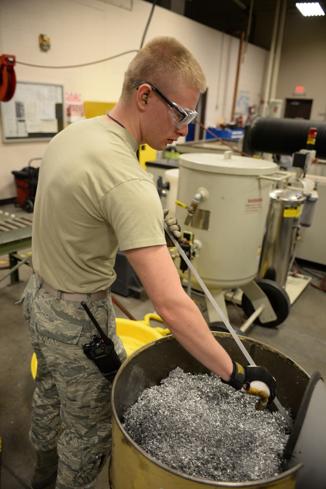 Senior Airman Brian Freeman, 28th Maintenance Squadron metals technician, collects scrap metal from a Haas VF 4 machine at Ellsworth Air Force Base, S.D., Jan. 6, 2016. To help the base’s budget, scrap metal is collected and then recycled. The metals flight creates aircraft parts that cannot be ordered through a supplies list. (U.S. Air Force photo by Airman Sadie Colbert/Released)