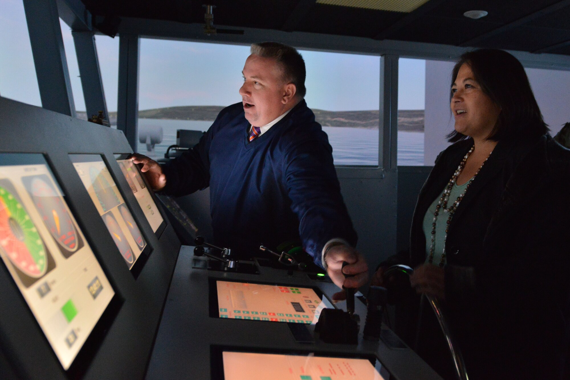 Donald Topping, director of the Maritime Intermodal Training department, assists the Honorable Debra Wada, Assistant Secretary of the Army for Manpower and Reserve Affairs, with driving a U.S. Army vessel simulator at Fort Eustis, Va., Jan. 11, 2015. Wada visited several Fort Eustis units to gain perspective on what the Army can do to better support Soldiers and their families. (U.S. Air Force photo by Staff Sgt. Natasha Stannard)