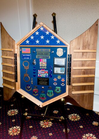 The elaborate shadow box presented to Air Force Office of Special Investigations Command Chief Master Sergeant Walker H. Cottingham during his retirement ceremony at Marine Corps Base, Quantico, Va., Jan. 8, depicts his 30-year military career. (U.S. Air Force photo/Michael Hastings)   