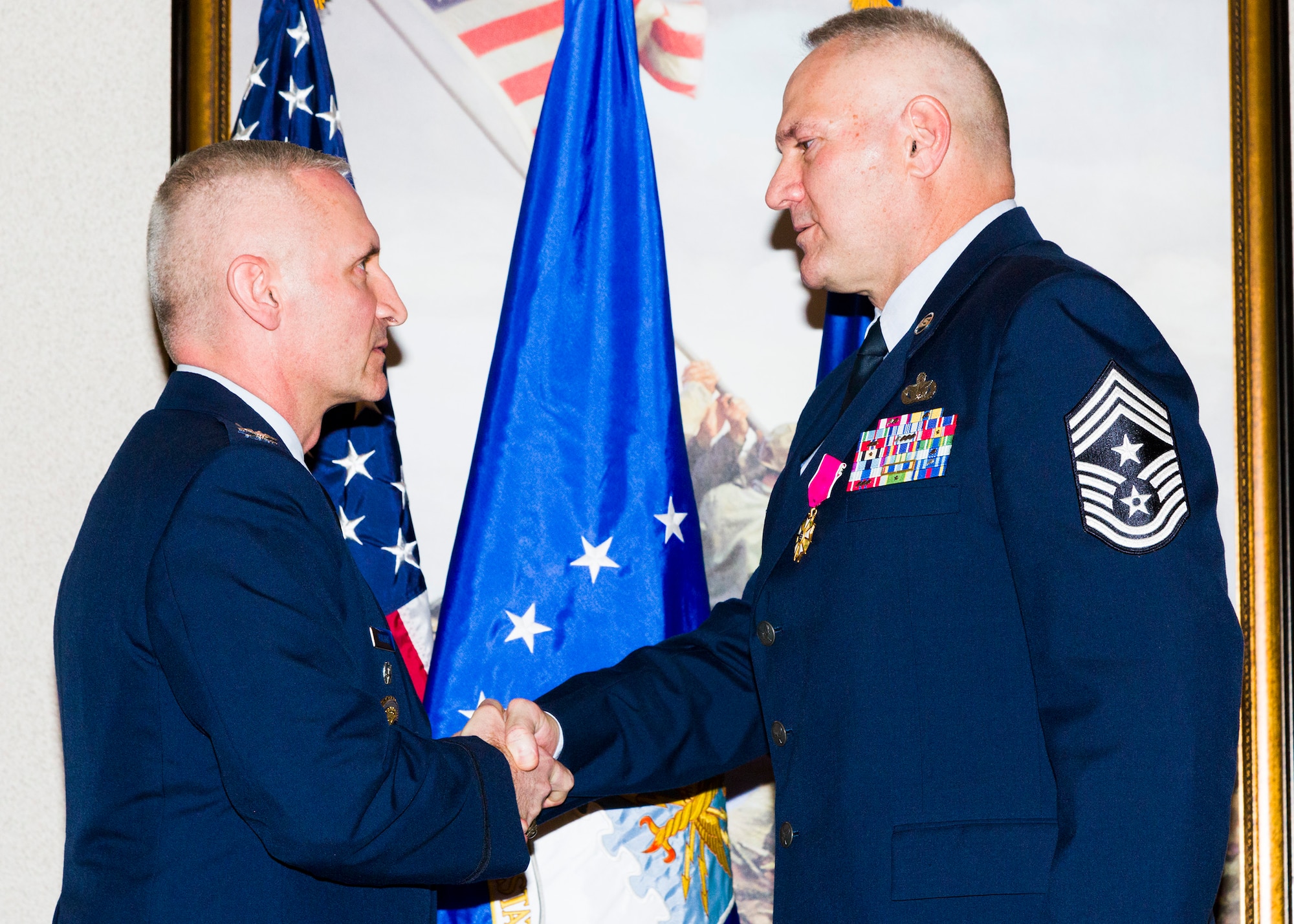 Col. Jeffrey Hurlbert, Director of Special Investigations and Senior AFOSI Representative to the Pentagon, congratulates AFOSI Command Chief Master Sergeant Walker H. Cottingham after presenting him with the Legion of Merit during Cottingham's retirement ceremony at Marine Corps Base Quantico, Va., Jan. 8. (U.S. Air Force photo/Michael Hastings)    