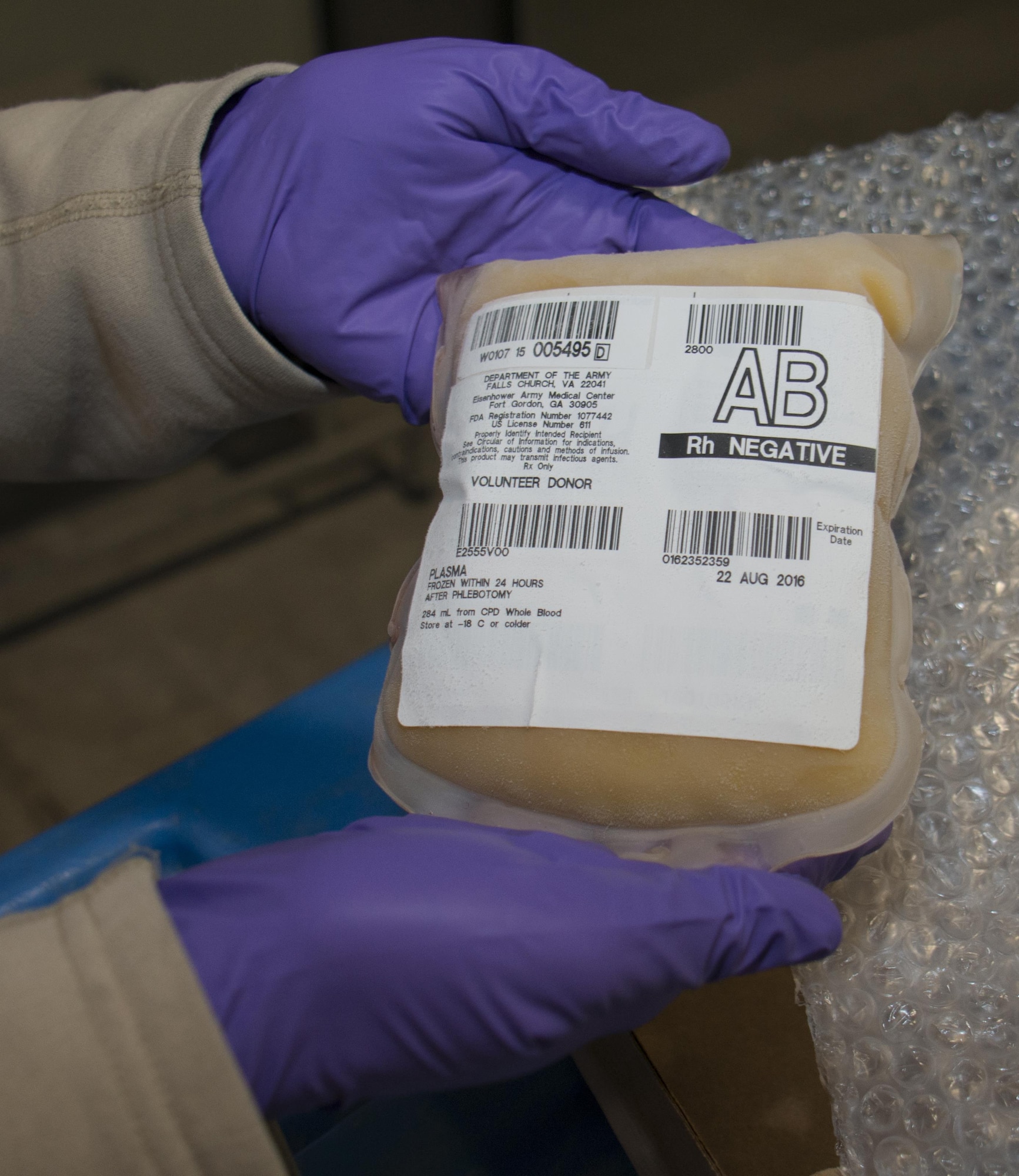Capt. Jennifer Swann, 379th Expeditionary Medical Group Blood Transshipment Center officer in charge, holds a package of AB plasma inside the Blood Transshipment Center at Al Udeid Air Base, Qatar, Jan. 13. The facility can hold thousands of red blood cell and plasma units. The center shipped nearly 23,000 units of blood to more than 30 forward operating locations in the U.S. Central Command area of responsibility in 2015. (U.S. Air Force photo by Tech. Sgt. James Hodgman/Released)