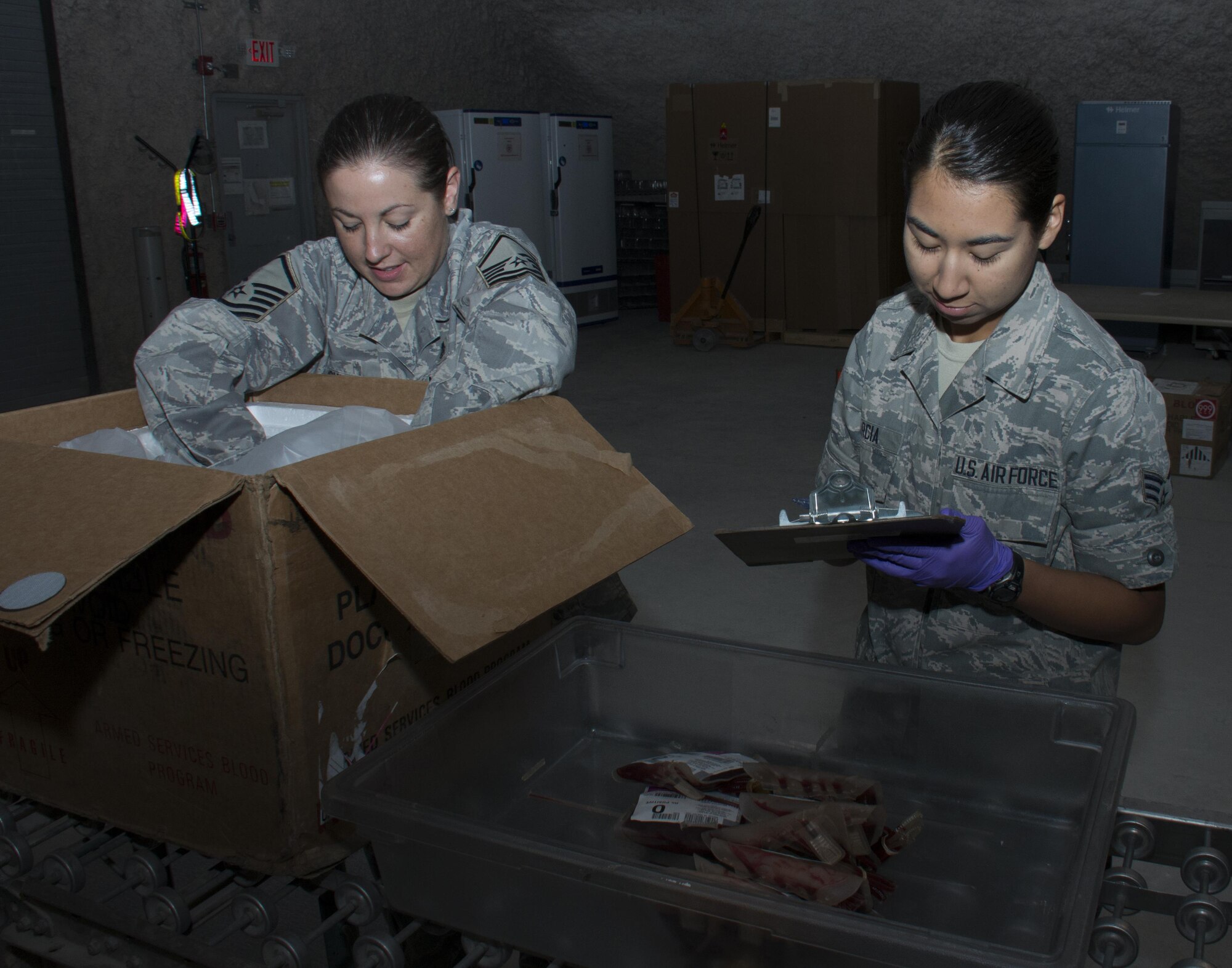 Master Sgt. Stephanie Washington (left), 379th Expeditionary Medical Support Squadron Diagnostics and Therapeutics flight chief, and Senior Airman Celina Garcia (right), 379 EMSS Blood Transshipment Center logistician, carefully pack red blood cell units for shipment inside the BTC at Al Udeid Air Base, Qatar, Jan. 13. The center shipped nearly 23,000 units of blood to more than 30 forward operating locations in the U.S. Central Command area of responsibility in 2015. (U.S. Air Force photo by Tech. Sgt. James Hodgman/Released)