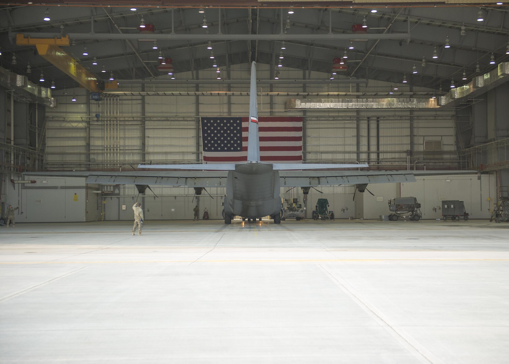 Crew chiefs from the 455th Expeditionary Aircraft Maintenance Squadron prepare to tow a C-130J Super Hercules to the flightline for an engine test at Bagram Airfield, Aghanistan, Jan. 12, 2016. The aircraft, used in support of Operation Freedom's Sentinel and NATO's Resolute Support mission, was housed in a hangar while it had an engine replaced. (U.S. Air Force photo/Tech. Sgt. Robert Cloys) 