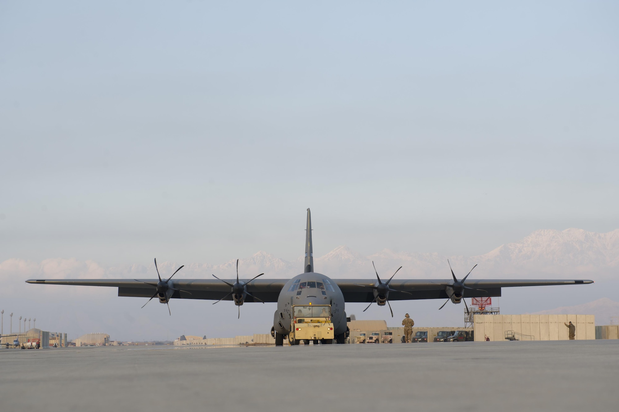 Airmen from the 455th Expeditionary Aircraft Maintenance Squadron tow a C-130J Super Hercules from the 774th Expeditionary Airlift Squadron to the flightline for an engine test at Bagram Airfield, Aghanistan, Jan. 12, 2016. The 455th EAMXS ensures that Super Hercules at Bagram are prepared for flight and return them to a mission-ready state once they land. (U.S. Air Force photo/Tech. Sgt. Robert Cloys) 