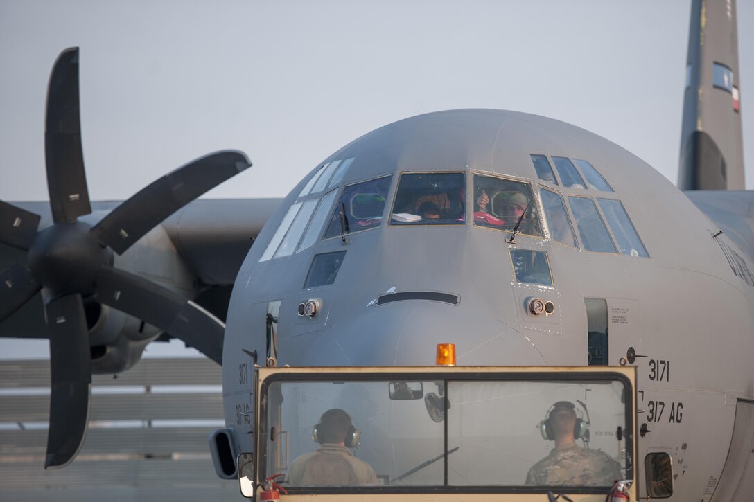 Senior Airman Eric Randall, 455th Expeditionary Aircraft Maintenance Squadron crew chief, gives a thumbs up from the cockpit of a C-130J Super Hercules as it is towed to the flightline for an engine test at Bagram Airfield, Aghanistan, Jan. 12, 2016. The 455th EAMXS ensures that Super Hercules at Bagram are prepared for flight and return them to a mission-ready state once they land. (U.S. Air Force photo/Tech. Sgt. Robert Cloys) 