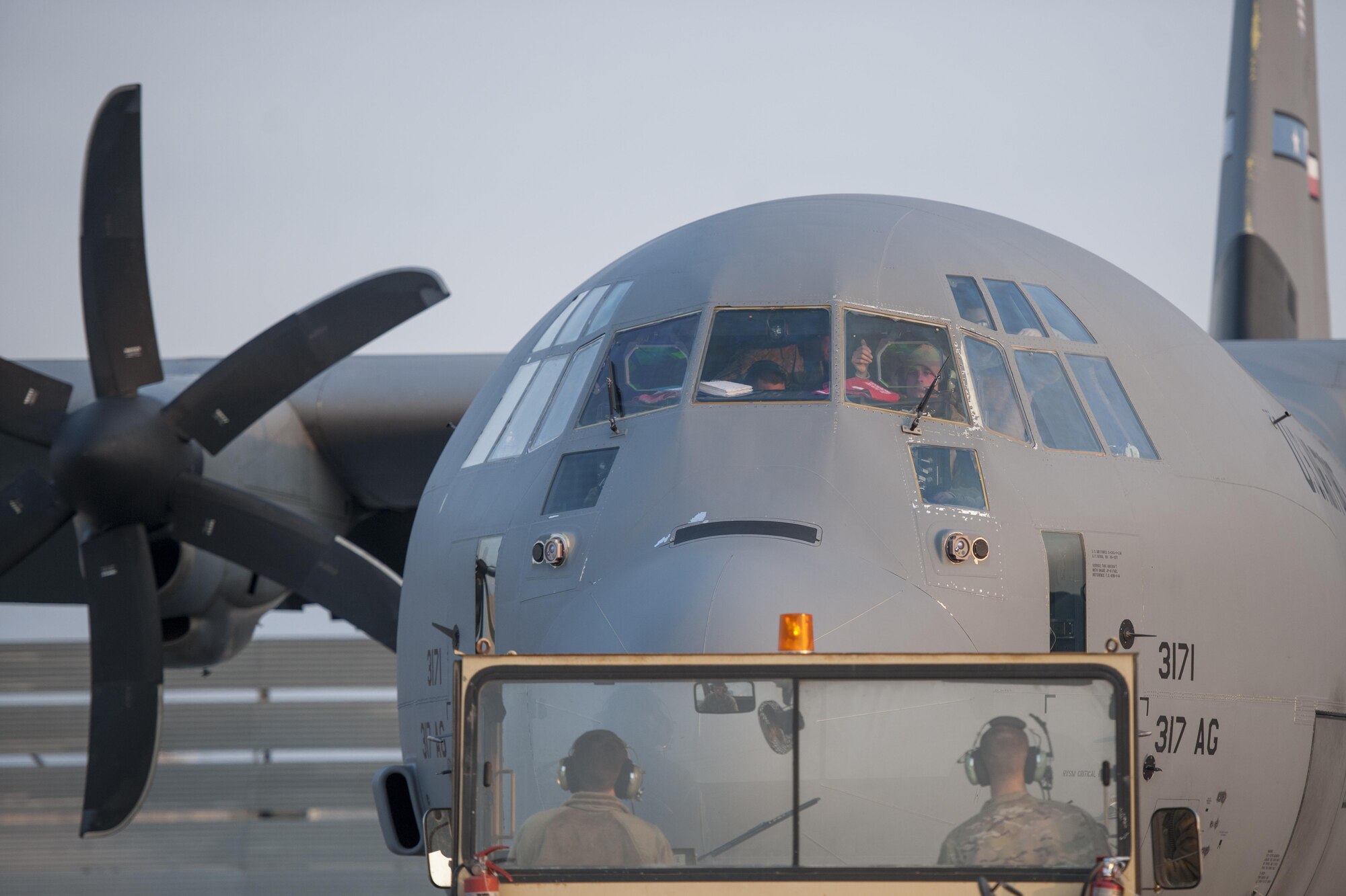 Senior Airman Eric Randall, 455th Expeditionary Aircraft Maintenance Squadron crew chief, gives a thumbs up from the cockpit of a C-130J Super Hercules as it is towed to the flightline for an engine test at Bagram Airfield, Aghanistan, Jan. 12, 2016. The 455th EAMXS ensures that Super Hercules at Bagram are prepared for flight and return them to a mission-ready state once they land. (U.S. Air Force photo/Tech. Sgt. Robert Cloys) 