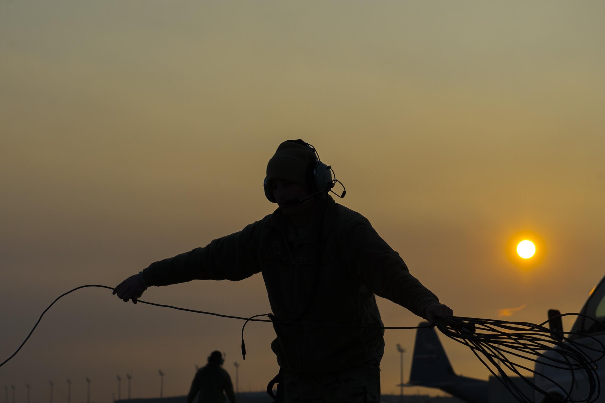 Senior Airman Eric Randall, 455th Expeditionary Aircraft Maintenance Squadron crew chief, bundles a communication cable attached to a C-130J Super Hercules as it is towed to the flightline for an engine test at Bagram Airfield, Aghanistan, Jan. 12, 2016. The 455th EAMXS ensures that Super Hercules at Bagram are prepared for flight and return them to a mission-ready state once they land. (U.S. Air Force photo/Tech. Sgt. Robert Cloys) 