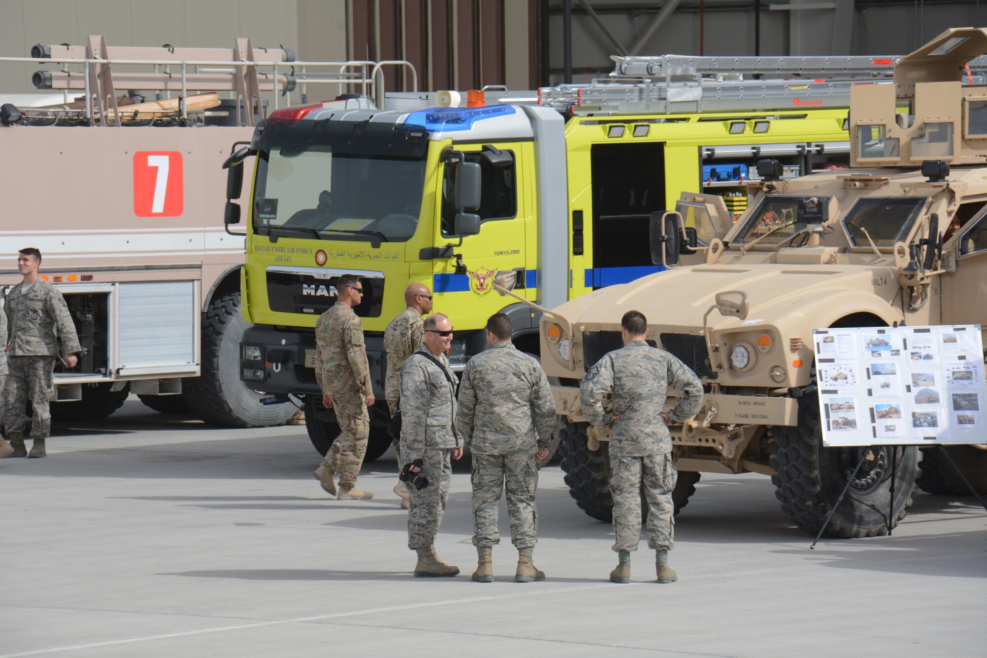 Service members tour several U.S. Air Force and Qatar Emiri Air Force emergency vehicles including fire trucks and mine resistant ambush protectant vehicles, at the annual Flight Line Fest at Al Udeid Air Base, Qatar, Jan. 10. Flight Line Fest is a joint partnership between the 379th Air Expeditionary Wing and QEAF held to foster relations between Qatar and the United States. (U.S. Air Force photo by Tech. Sgt. James Hodgman/Released)