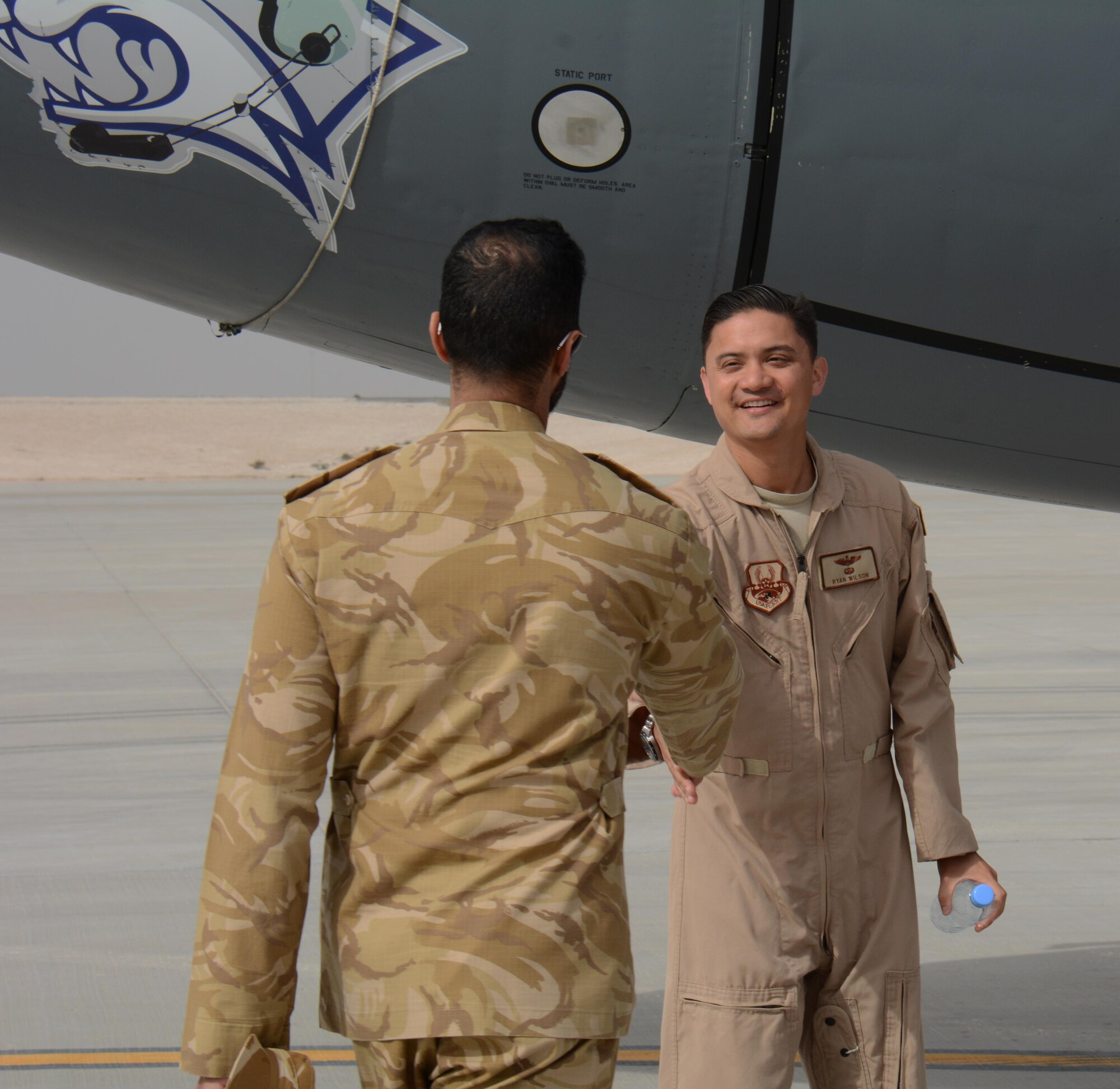 Capt. Ryan, 340th Expeditionary Aerial Refueling Squadron pilot, greets a member of the Qatar Emiri Air Force, during the annual Flight Line Fest at Al Udeid Air Base, Qatar Jan. 10. The event is a joint partnership between the 379th Air Expeditionary Wing and the QEAF and featured nine aircraft including the B-1B Lancer and KC-135 Stratotanker. (U.S. Air Force photo by Tech. Sgt. James Hodgman/Released)