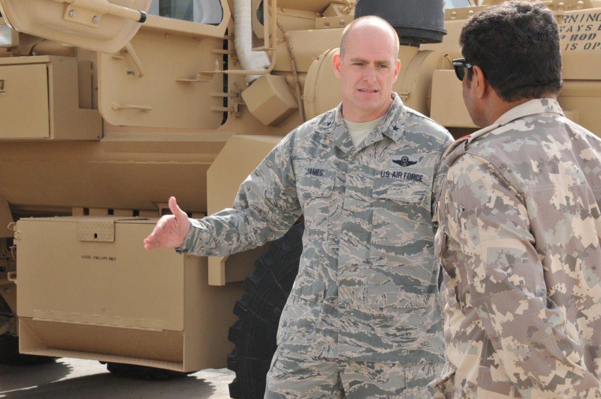 Brig. Gen. Darren James, 379th Air Expeditionary Wing commander, shows a member of the Qatar military a mine resistant ambush protectant vehicle during Flight Line Fest at Al Udeid Air Base, Qatar Jan. 10. Flight Line Fest is a joint partnership between the 379th AEW and the Qatar Emiri Air Force held to foster relations between Qatar and the United States. (U.S. Air Force photo by Tech. Sgt. Terrica Y. Jones)