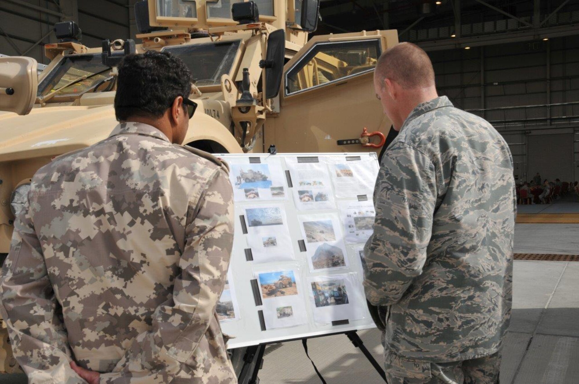 Brig. Gen. Darren Jones (right), 379th Air Expeditionary Wing commander, shows a member of the Qatar military a mine resistant protectant vehicle at Flight Line Fest at Al Udeid Air Base, Qatar Jan. 10. Flight Line Fest is a joint partnership between the 379th Air Expeditionary Wing and Qatar Emiri Air Force held to foster relations between Qatar and the United States. (U.S. Air Force photo by Tech. Sgt. Terrica Y. Jones)