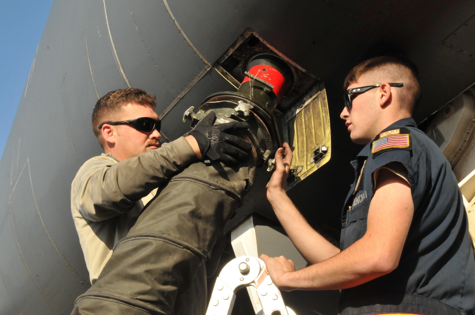 Senior Airman Brandon Wilkins (left) and Airmen 1st Class Jacob Shores (right), perform a post-flight inspection on a B-1 B Lancer Jan. 11 at Al Udeid Air Base, Qatar. Wilkins and Shores, maintainers deployed from Ellsworth Air Force Base, South Dakota, hook up power and air to the B-1 which allows the jet to stay cool while it receives gas. (U.S. Air Force photo by Tech. Sgt. Terrica Y. Jones/Released)