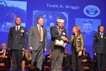 Todd Briggs, who works as an acquisition supervisor in DLA Land and Maritime Supplier Operations, was inducted into the Ohio Veterans Hall of Fame during a ceremony this past November at the Lincoln Theatre in downtown Columbus. He is presented his plaque by Ohio Lt. Governor Mary Taylor (right) and Chip Tansill (left), Ohio Director of Veterans Affairs. Briggs joins his father Morris as the only father-son duo in the hall.