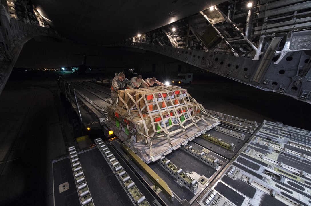 U.S. Air Force airmen load cargo onto a C-17 Globemaster III aircraft at Al Udeid Air Base, Qatar, in support of Operation Resolute Support, Jan. 13, 2016. The airmen are assigned to the 8th Expeditionary Air Mobility Squadron. U.S. Air Force photo by Staff Sgt. Corey Hook