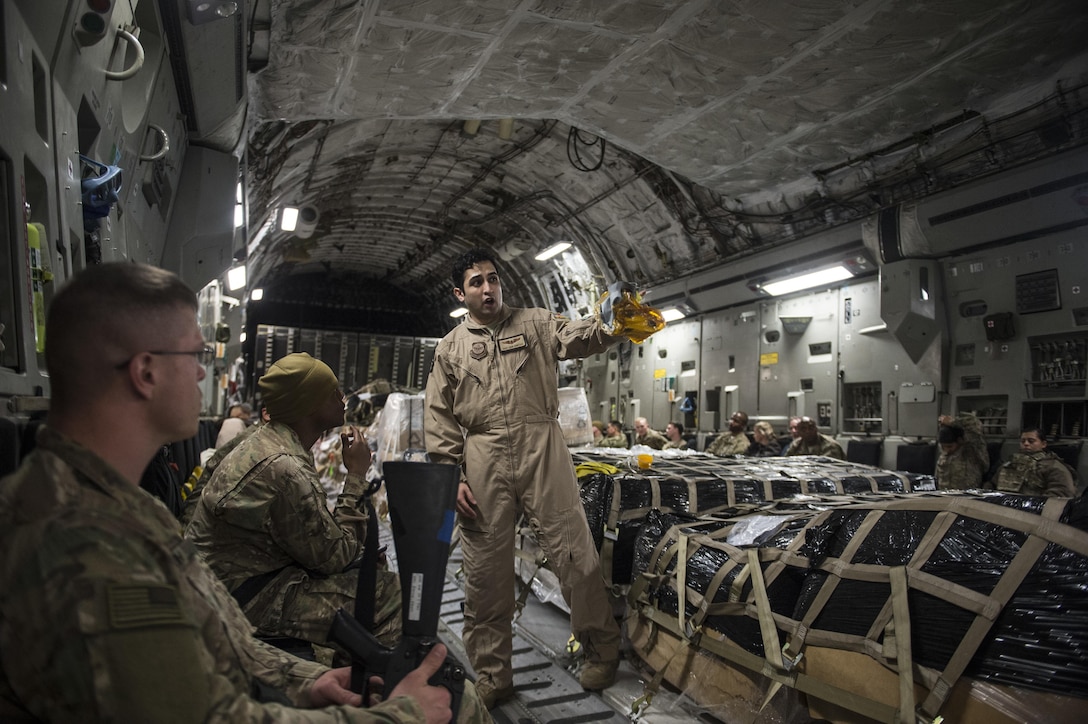 U.S. Air Force Staff Sgt. Jose Montoya, center, briefs passengers before taking flight on a C-17 Globemaster III from Al Udeid Air Base, Qatar, in support of Operation Resolute Support, Jan. 13, 2016. Montoya is a loadmaster assigned to the 816th Expeditionary Airlift Squadron. U.S. Air Force photo by Staff Sgt. Corey Hook