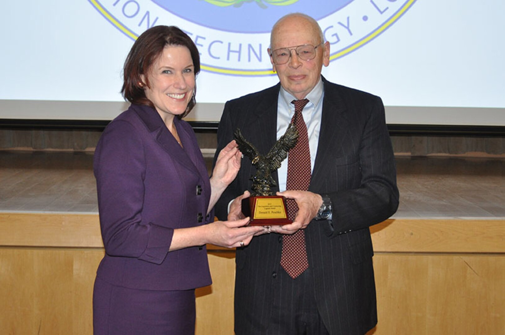 Pictured from left, Defense Procurement and Acquisition Policy Director Claire Grady presents Donald Peschka with the 2015 Under Secretary of Defense for Acquisition, Technology and Logistics Acquisition and Contracting Legends Award during a ceremony at the Pentagon Jan. 12.