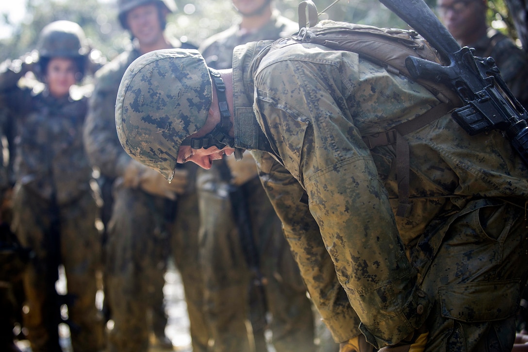 U.S. Navy Petty Officer 1st Class Joshua W. Karr takes a moment to collect himself after crawling through a mud-filled trench during jungle warfare training on Okinawa, Japan, Jan. 12, 2016. U.S. Marines with the Jungle Warfare Training Center hosted the event. Karr is a construction mechanic assigned to Naval Mobile Construction Battalion 3. U.S. Navy photo by Petty Officer 1st Class Michael Gomez