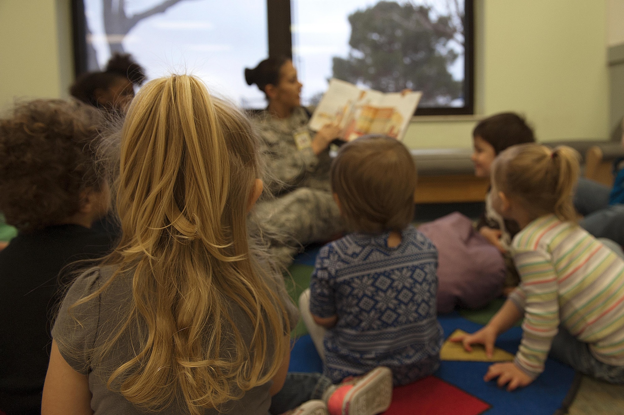 Children gather around a service member during the Martin Luther King Jr. Book Reading at the Child Development Center on Goodfellow Air Force Base, Texas, Jan. 14, 2016. The book reading celebrates the impact of Martin Luther King Jr.’s life on our nation and Air Force. (U.S. Air Force photo by Airman 1st Class Caelynn Ferguson/Released)