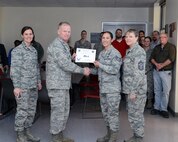 Staff Sgt. Vanessa Flores, center-right, 47th Civil Engineer Squadron NCO in charge of Readiness and Emergency Management Flight, accepts the “XLer of the Week” award from Col. Darrell Judy, center-left, 47th Flying Training Wing vice commander, and is accompanied by Lt. Col. Tammie Harris, left, 47th CES Commander, and Chief Master Sgt. Teresa Clapper, right, 47th FTW command chief, here, Jan. 13, 2016. The XLer is a weekly award chosen by wing leadership and is presented to those who consistently make outstanding contributions to their unit and Laughlin. (U.S. Air Force photo by Senior Airman Jimmie D. Pike)