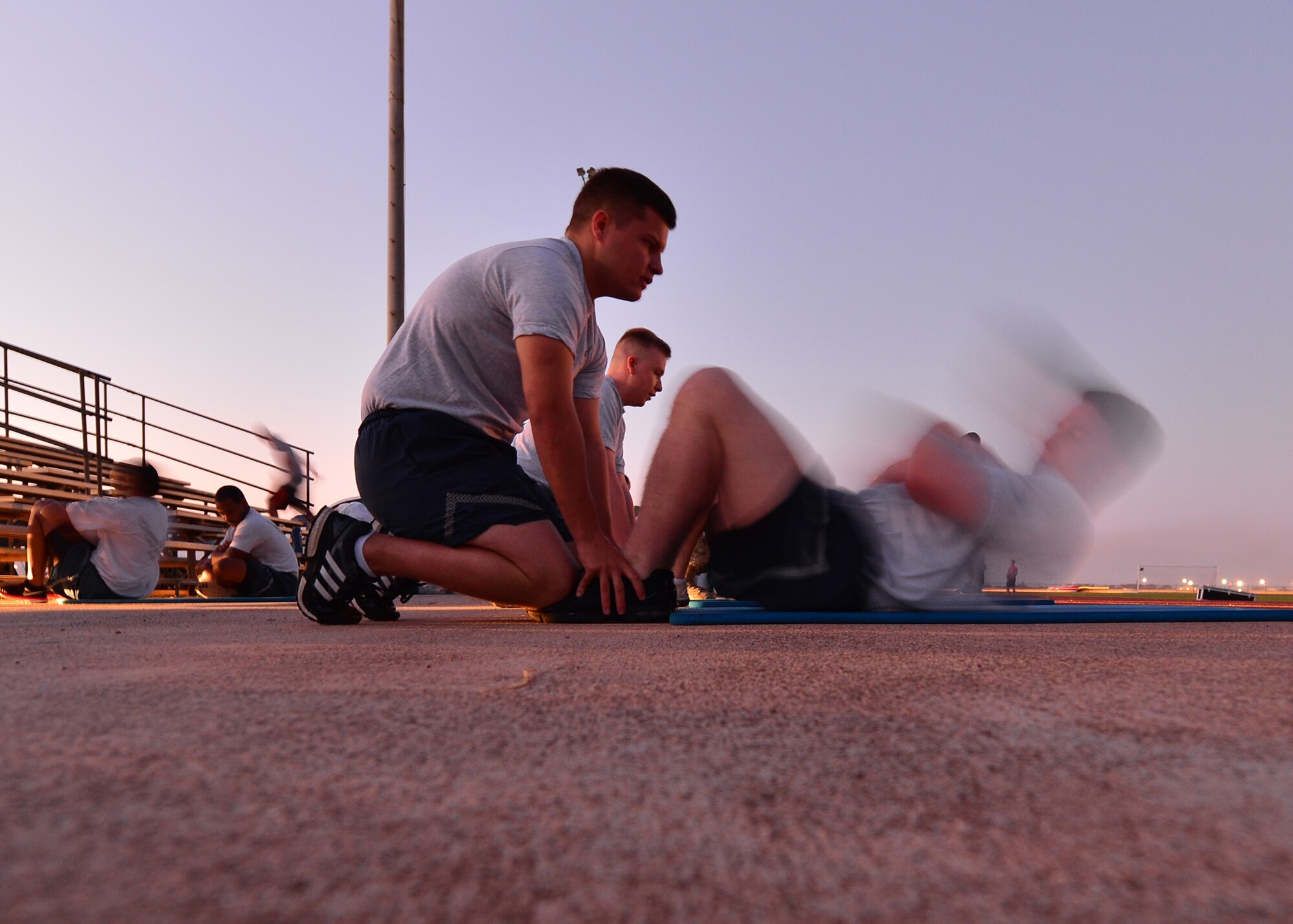 Airmen from the 15th Wing perform sit-ups, one of the four fitness componentsof the Air Force fitness assessment at Earhart Field on Joint Base Pearl Harbor-Hickam, Hawaii, Jan. 14, 2016. The goal of the Fitness Program is to motivate all members to participate in a year round physical conditioning program that emphasizes total fitness, to include proper aerobic conditioning, muscular fitness training, and healthy eating. (U.S. Air Force photo by Tech. Sgt. Aaron Oelrich/Released)   