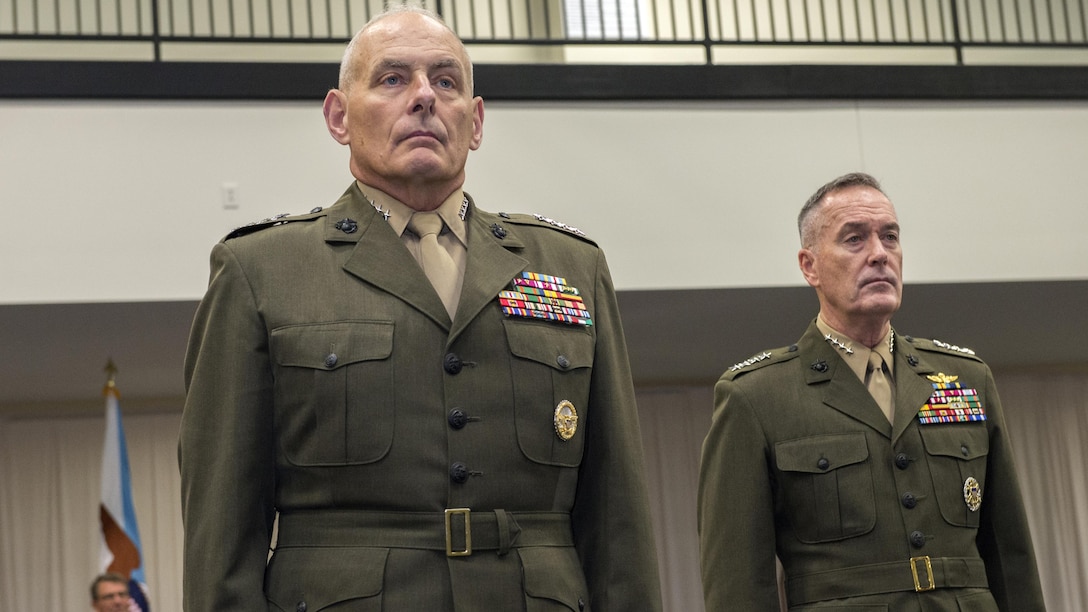 U.S. Marine Gen. John F. Kelly, left, and U.S. Marine Corps Gen. Joseph F. Dunford, chairman of the Joint Chiefs of Staff, stand at attention during the U.S. Southern Command change of command ceremony at SOUTHCOM headquarters in Doral, Fla., Jan. 14, 2016. U.S. Navy Adm. Kurt W. Tidd is the new SOUTHCOM commander, succeeding Kelly.