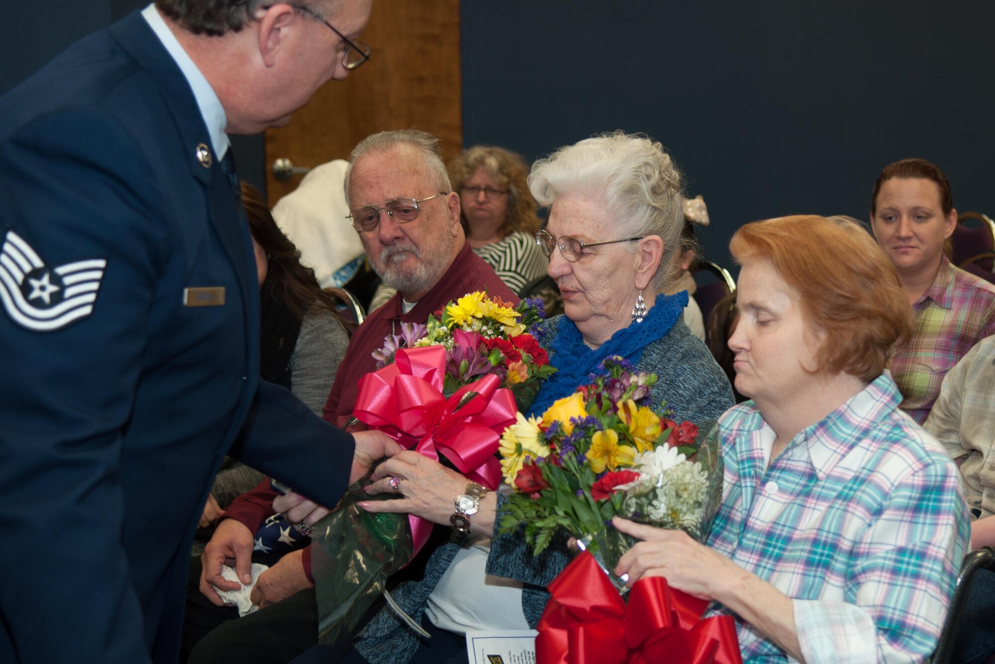 U.S. Air Force Tech. Sgt. Melvin Cargill presents his mother, Ina Cargill, and wife, Robbie Cargill, with flowers during his retirement ceremony on Barksdale Air Force Base, La. on Jan. 9, 2016. Cargill is retiring from the 307th Security Forces Squadron after 33 years of service. (U.S. Air Force photo by Master Sgt. Dachelle Melville/Released)