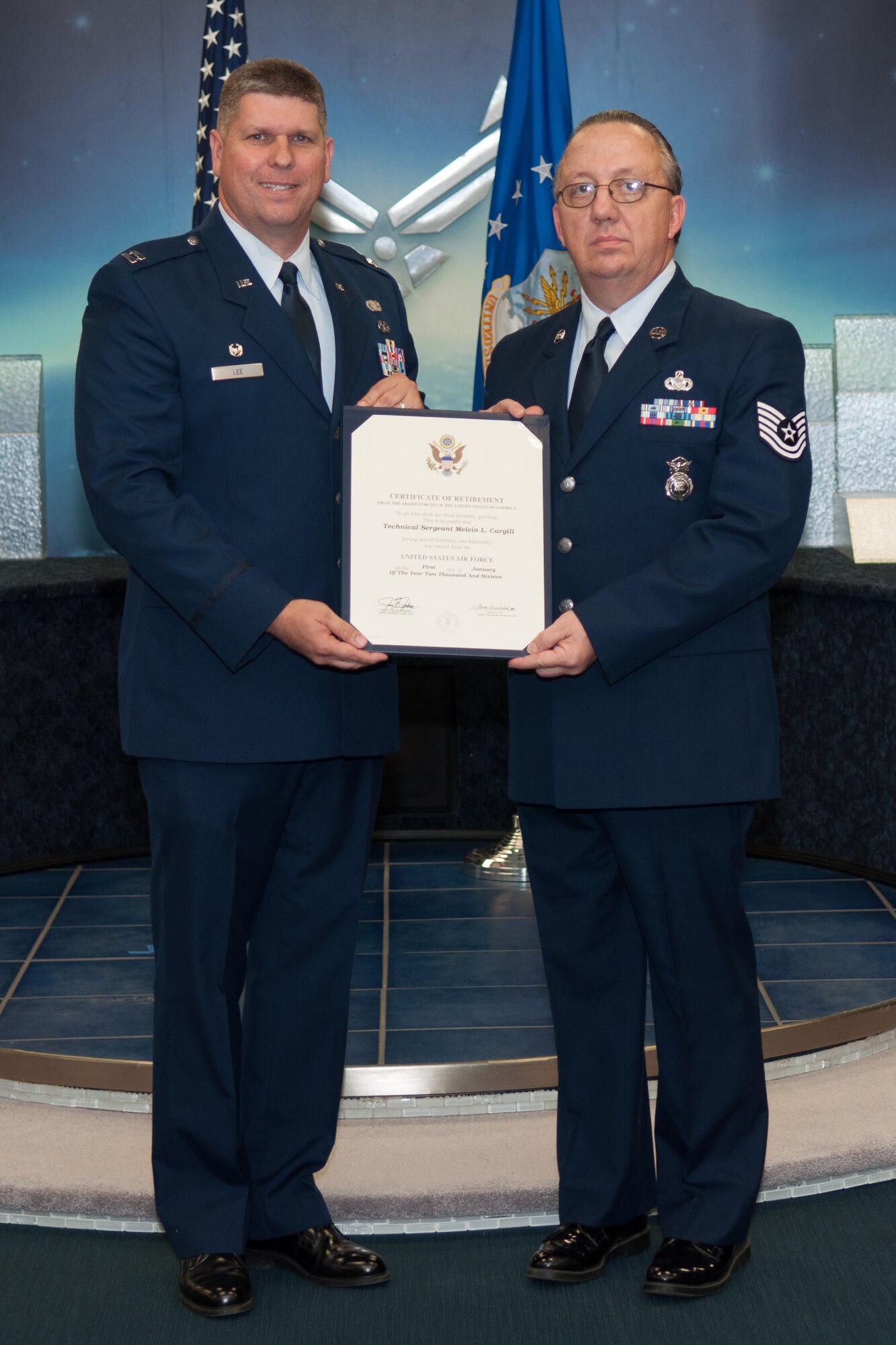 The U.S. Air Force 307th Security Forces Squadron Commander, Capt. Mark Lee, presents Tech. Sgt. Melvin Cargill a certificate of retirement on Barksdale Air Force Base, La. on Jan. 9, 2016. Cargill is retiring after 33 years of service. (U.S. Air Force photo by Master Sgt. Dachelle Melville/Released)