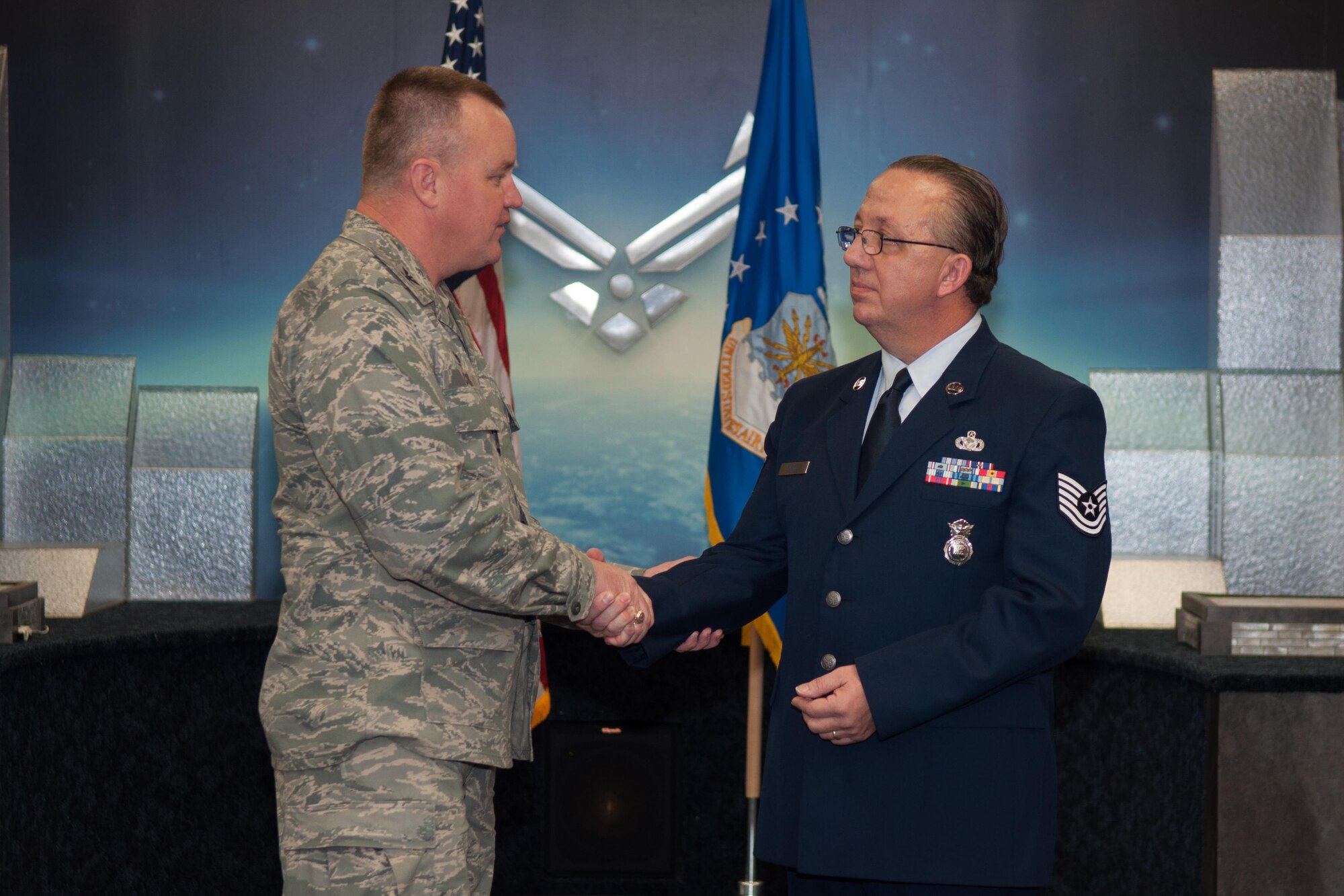 U.S. Air Force 307th Bomb Wing Commander, Col. Bruce Cox, presents Tech. Sgt. Melvin Cargill with a coin in honor of his retirement on Jan. 9, 2016 on Barksdale Air Force Base, La. Cargill is retiring from the 307th Security Forces Squadron after 33 years of service. (U.S. Air Force photo by Master Sgt. Dachelle Melville/Released)
