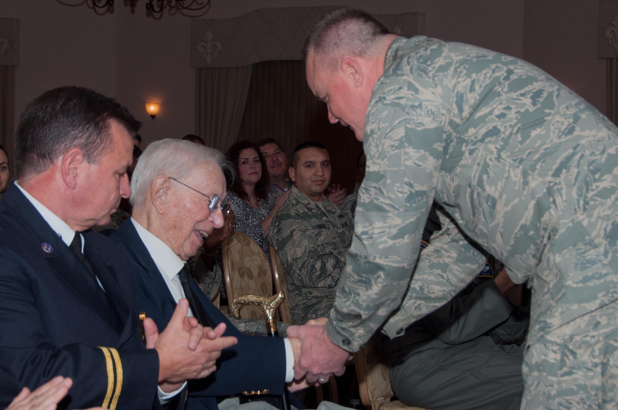 U.S. Air Force Col. Bruce Cox, 307th Bomb Wing commander, presents a coin to Lewis Doelling, a WWII veteran and father of retiring Chief Master Sgt. Michael Doelling on Jan. 09, 2016, Barksdale Air Force Base, La.  Seven generations of Doellings have served in the United States military. (U.S. Air Force photo by Master Sgt. Laura Siebert/Released)