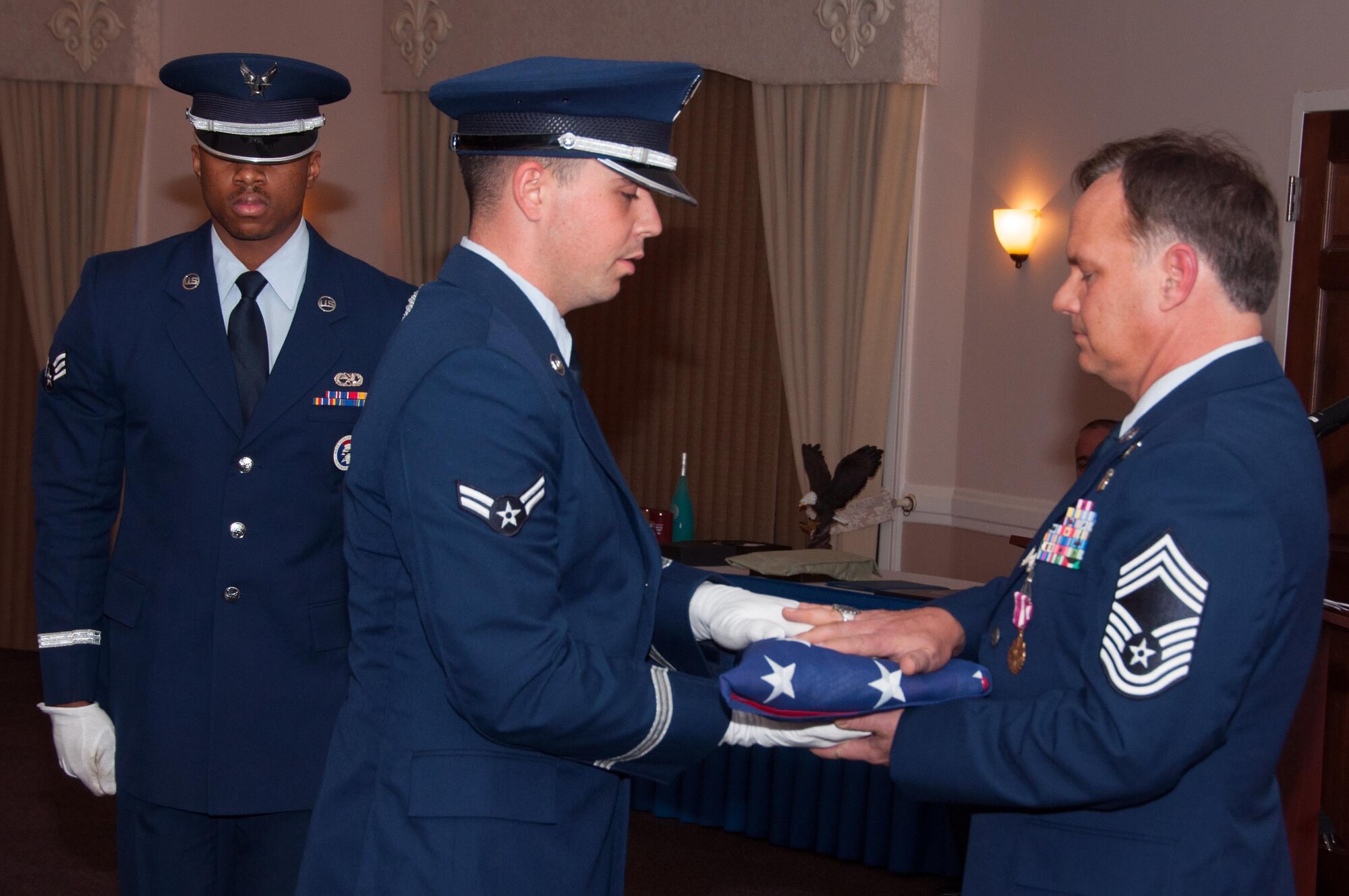 U.S. Air Force Chief Master Sgt. Michael Doelling receives an American flag during his retirement ceremony on Jan. 09, 2016, Barksdale Air Force Base, La. Doelling then presented the flag to his father who is a WWII veteran. (U.S. Air Force photo by Master Sgt. Laura Siebert/Released)