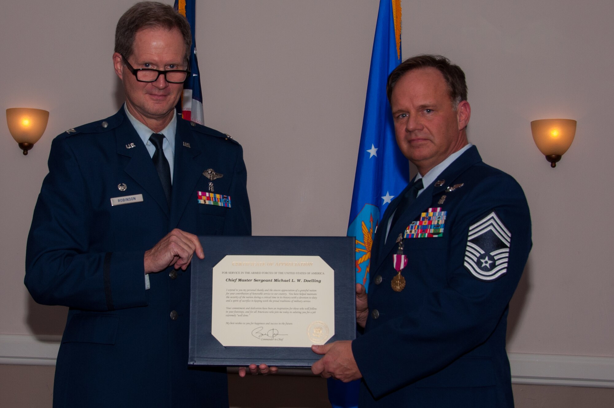 U.S. Air Force Retired Col. Dean Robinson presents a Certificate of Appreciation from President Barack Obama to Chief Master Sgt. Michael Doelling during a retirement ceremony on Jan. 09, 2016, Barksdale Air Force Base, La. Doelling is retiring from the Air Force after 30 years of service. (U.S. Air Force photo by Master Sgt. Laura Siebert /Released)