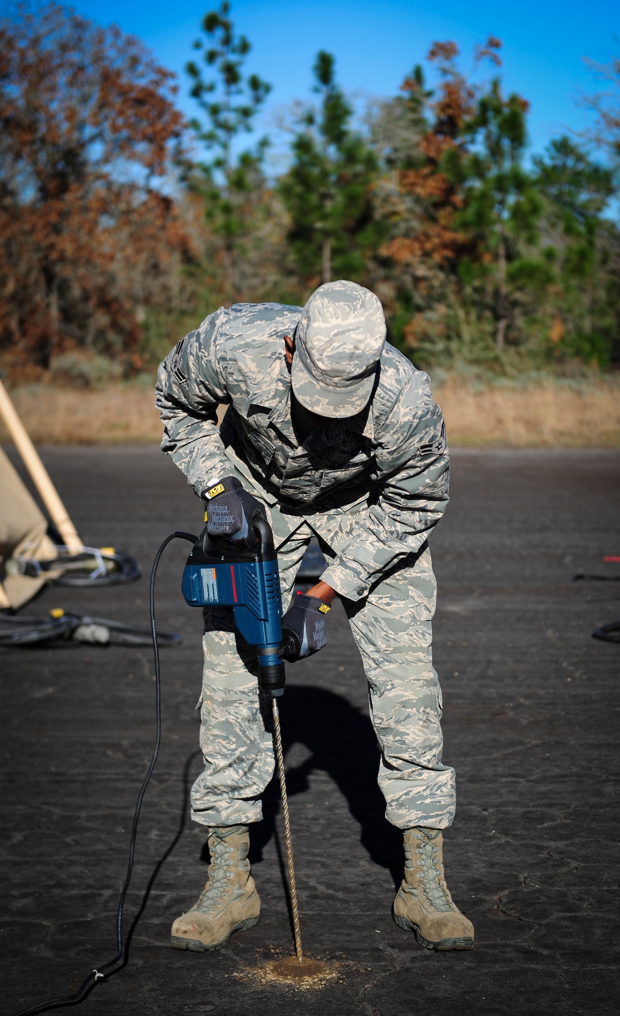Airman 1st Class Brent Taylor, a heavy equipment operator with the 1st Special Operations Civil Engineering Squadron, drills a pilot hole into the pavement for metal rods during exercise Frigid Archer at Eglin Range, Fla., Jan. 6, 2016. There was a total of 250 Airmen participating in the exercise. Sixty Airmen came from the 1st SOCES. (U.S. Air Force photo by Senior Airman Meagan Schutter)