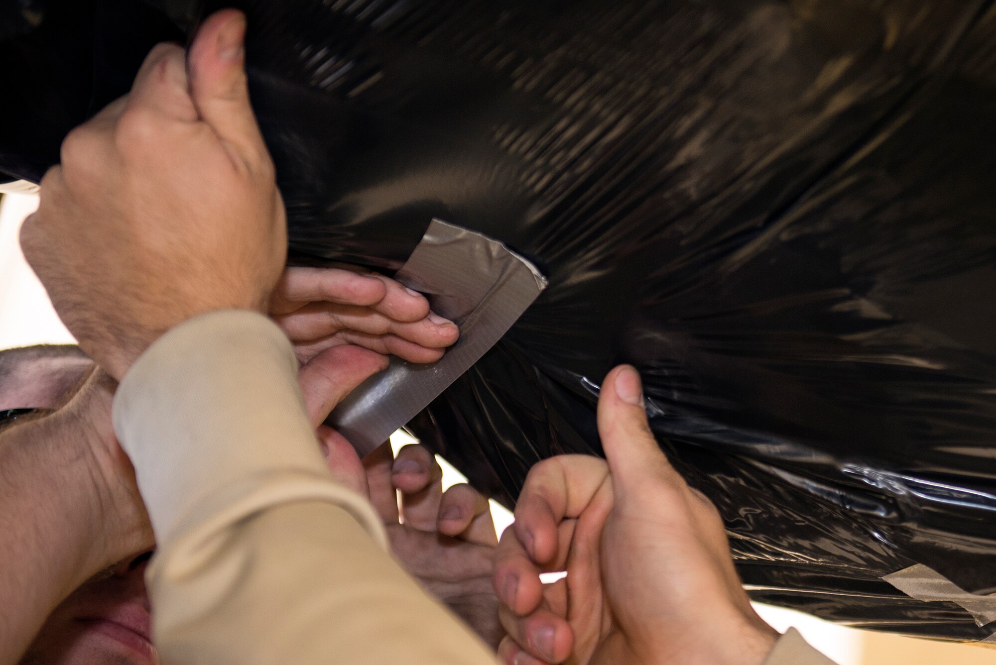 Airmen from the 23d Component Maintenance Squadron tape down engine shipment wrap, Jan. 12, 2016, at Moody Air Force Base, Ga. The propulsion flight is responsible for securely wrapping the engine to ensure safety during ground transport. (U.S. Air Force photo by Airman 1st Class Greg Nash/Released) 