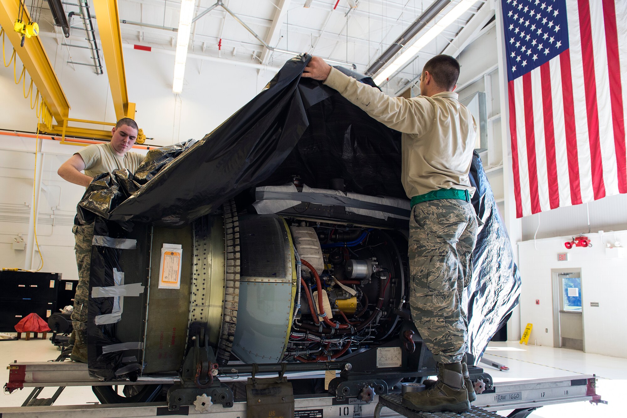 U.S. Air Force Airman 1st Class Jesse Mendheim, left, and Senior Airman Anthony Armeli, 23d Component Maintenance Squadron aerospace propulsion flight journeymen, perform an engine wrap on a TF-34 engine, Jan. 12, 2016, at Moody Air Force Base, Ga. The propulsion flight receives, breaks down and repairs Moody’s A-10C Thunderbolt II aircraft engines. (U.S. Air Force photo by Airman 1st Class Greg Nash/Released) 