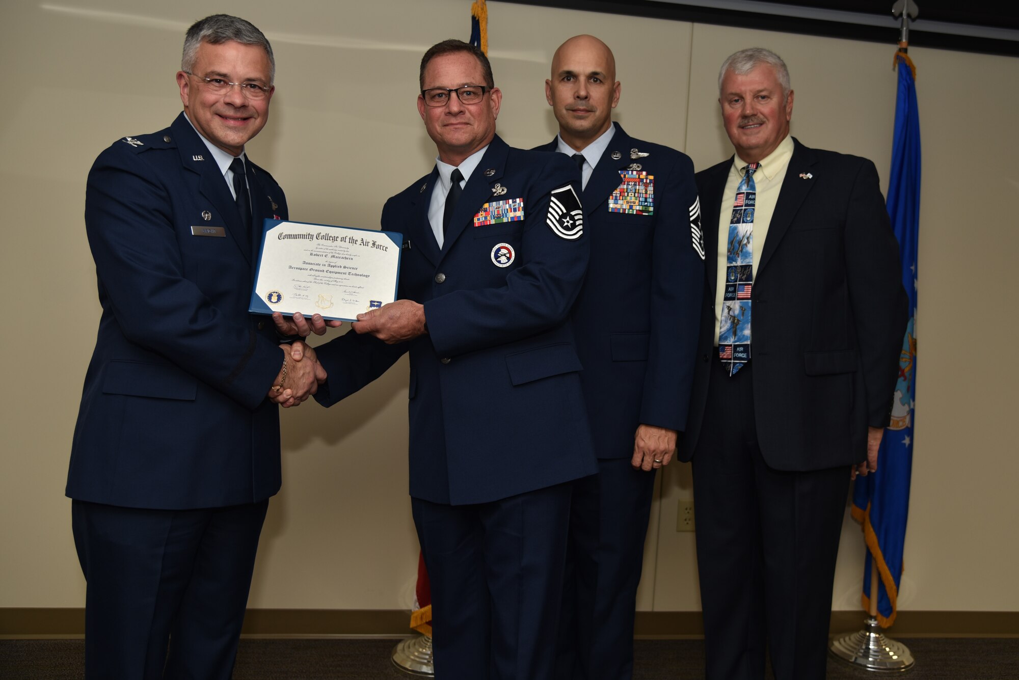 Master Sgt. Robert E. Maceachern receives his Community College of the Air Force Associates of Applied Science degree in aerospace ground and equipment technician during a graduation ceremony held at MacDill Air Force Base, Florida, June 9, 2016. In attendance were graduates, their commanders, supervisors, co-workers and family members. Each year, CCAF students earn more than 1.6 million hours of college credits, and the college has awarded more than 335,000 degrees since 1977. (U.S. Air Force photo by Staff Sgt. Adam Borgman)