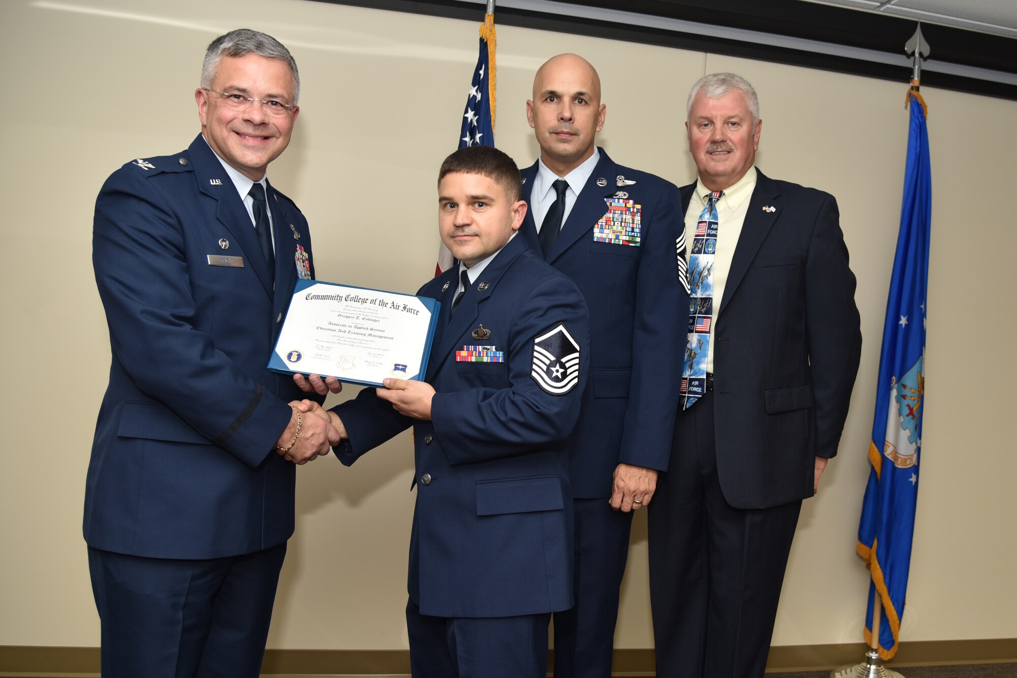 Master Sgt. Gregory Enfinger receives his Community College of the Air Force Associates of Applied Science degree in education and training management during a graduation ceremony held at MacDill Air Force Base, Florida, June 9, 2016. In attendance were graduates, their commanders, supervisors, co-workers and family members. Each year, CCAF students earn more than 1.6 million hours of college credits, and the college has awarded more than 335,000 degrees since 1977. (U.S. Air Force photo by Staff Sgt. Adam Borgman)
