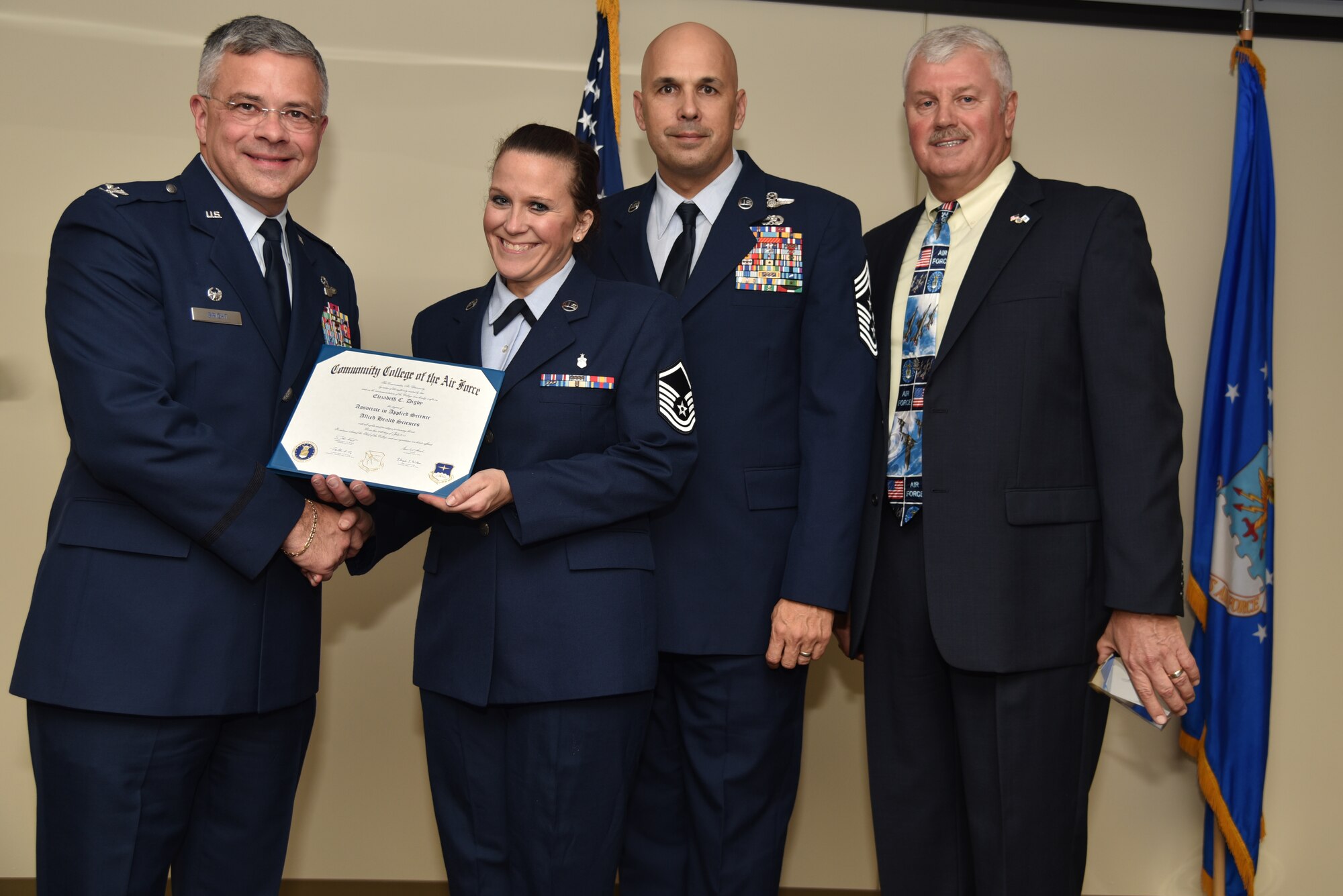 Master Sgt. Elizabeth Digby receives her Community College of the Air Force Associates of Applied Science degree in allied health science during a graduation ceremony held at MacDill Air Force Base, Florida, June 9, 2016. In attendance were graduates, their commanders, supervisors, co-workers and family members. Each year, CCAF students earn more than 1.6 million hours of college credits, and the college has awarded more than 335,000 degrees since 1977. (U.S. Air Force photo by Staff Sgt. Adam Borgman)