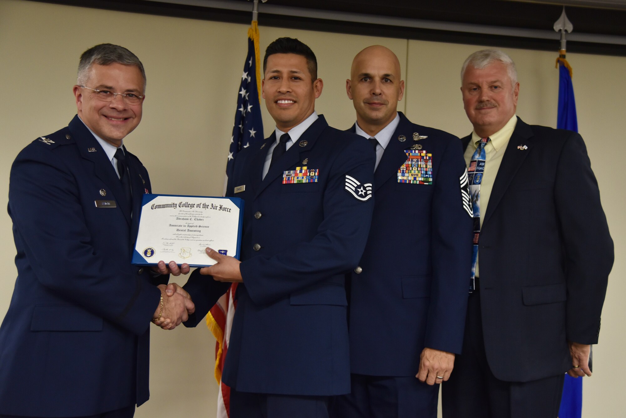 Staff Sgt. Abraham Chavez receives his Community College of the Air Force Associates of Applied Science degree in dental assisting during a graduation ceremony held at MacDill Air Force Base, Florida, June 9, 2016. In attendance were graduates, their commanders, supervisors, co-workers and family members. Each year, CCAF students earn more than 1.6 million hours of college credits, and the college has awarded more than 335,000 degrees since 1977. (U.S. Air Force photo by Staff Sgt. Adam Borgman)