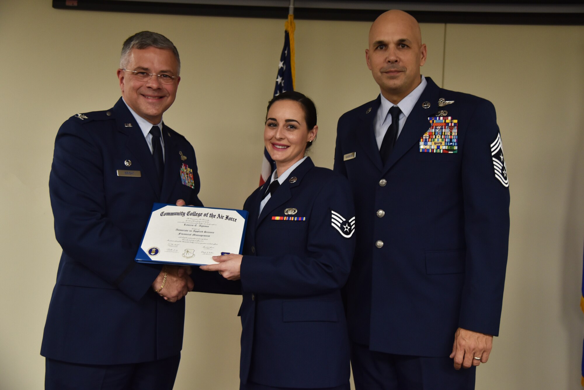 Staff Sgt. Lauren Agnone receives her Community College of the Air Force Associates of Applied Science degree in financial management during a graduation ceremony held at MacDill Air Force Base, Florida, June 9, 2016. Supporting her continuing her education, Agnone’s parents, brother-in-law, and roommate attended the ceremony. Agnone is only three courses from earning a Bachelor degree in Marketing. (U.S. Air Force photo by Staff Sgt. Adam Borgman)