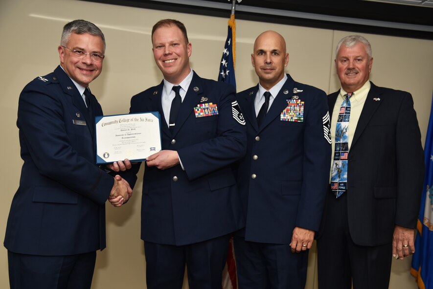 Senior Master Sgt. Daniel Prill receives his Community College of the Air Force Associates of Applied Science degree in transportation during a graduation ceremony held at MacDill Air Force Base, Florida, June 9, 2016. In attendance were graduates, their commanders, supervisors, co-workers and family members. Each year, CCAF students earn more than 1.6 million hours of college credits, and the college has awarded more than 335,000 degrees since 1977. (U.S. Air Force photo by Staff Sgt. Adam Borgman)