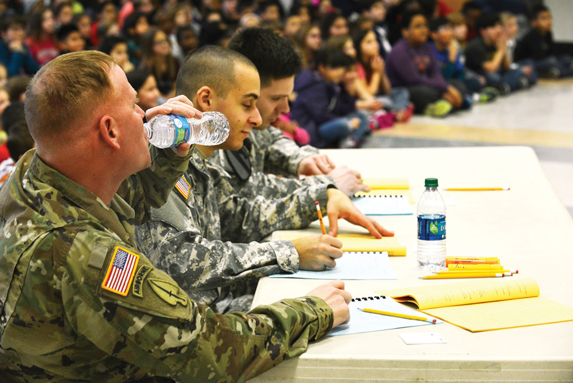 Lt. Col. John Gavin, 17th Combat Sustainment Support Battalion commander (left), 2nd Lt. Kenneth Canali, a platoon leader with the 17th CSSB (center), and Sgt. Andrew Csog, 17th a squad leader with the 17th CSSB prepare for Ursa Major's spelling bee to begin January 7 at the school. Volunteers from the 17th CSSB served as judges as part of the school partnership program Joint Base Elmendorf-Richardson has with 29 Anchorage School District locations. (U.S. Air Force photo by Airman 1st Class Kyle Johnson/Released)