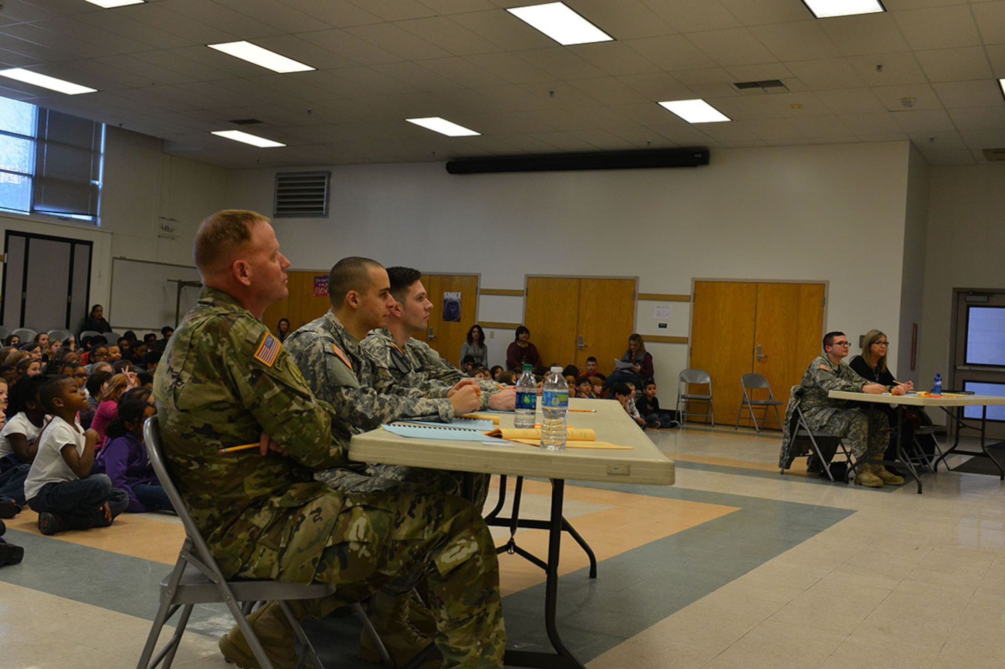 Lt. Col. John Gavin, 17th Combat Sustainment Support Battalion commander (left), 2nd Lt. Kenneth Canali, a platoon leader with the 17th CSSB (center), and Sgt. Andrew Csog, 17th a squad leader with the 17th CSSB prepare for Ursa Major's Spelling bee to begin January 7 at the school. Volunteers from the 17th CSSB served as judges as part of the school partnership program Joint Base Elmendorf-Richardson has with 29 Anchorage School District locations. (U.S. Air Force photo by Airman 1st Class Kyle Johnson/Released)