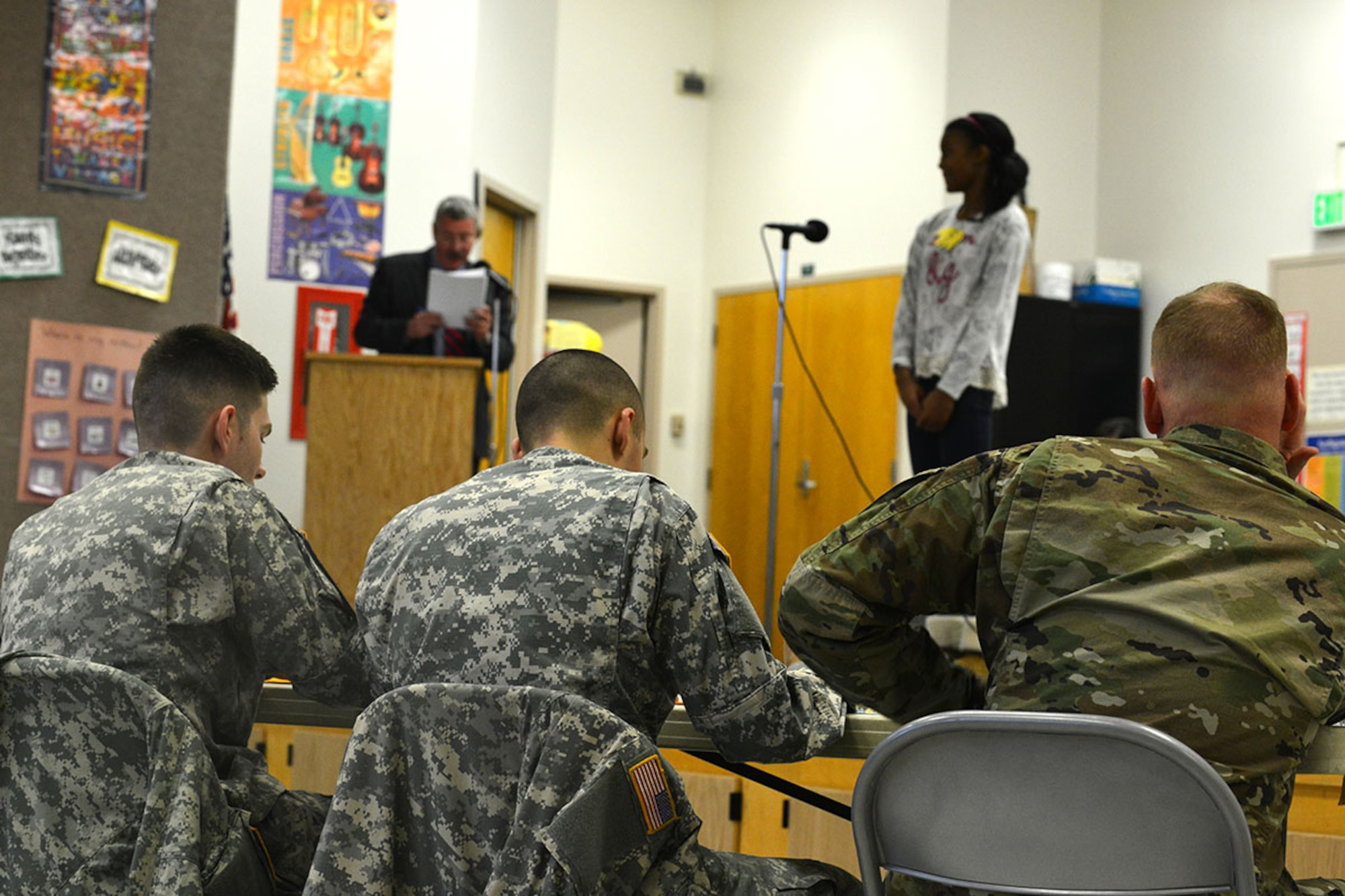 U.S. Army Sgt. Andrew Csog, a squad leader with the 17th Combat Sustainment Support Battalion (left), 2nd Lt. Kenneth Canali, a platoon leader with the 17th CSSB (center), and  Lt. Col. John Gavin, 17th CSSB commander listen to a student spell Arch as part of Ursa Major's spelling bee Jan. 7 at the school. Volunteers from the 17th CSSB served as judges as part of Joint Base Elmendorf-Richardson’s partnership program with 29 Anchorage School District locations. (U.S. Air Force photo by Airman 1st Class Kyle Johnson/Released)